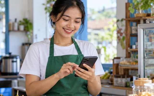 Pemilik usaha memantau omzet toko secara real-time dari smartphone