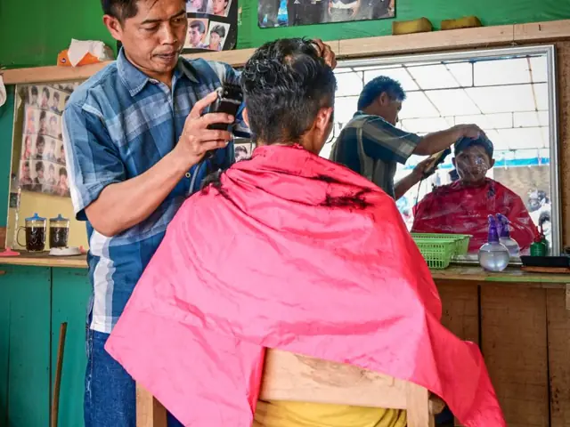 Tukang cukur melayani pelanggan
