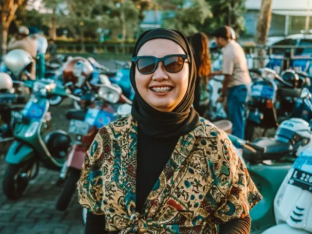 Pemilik rental berdiri di depan deretan motor sewaan